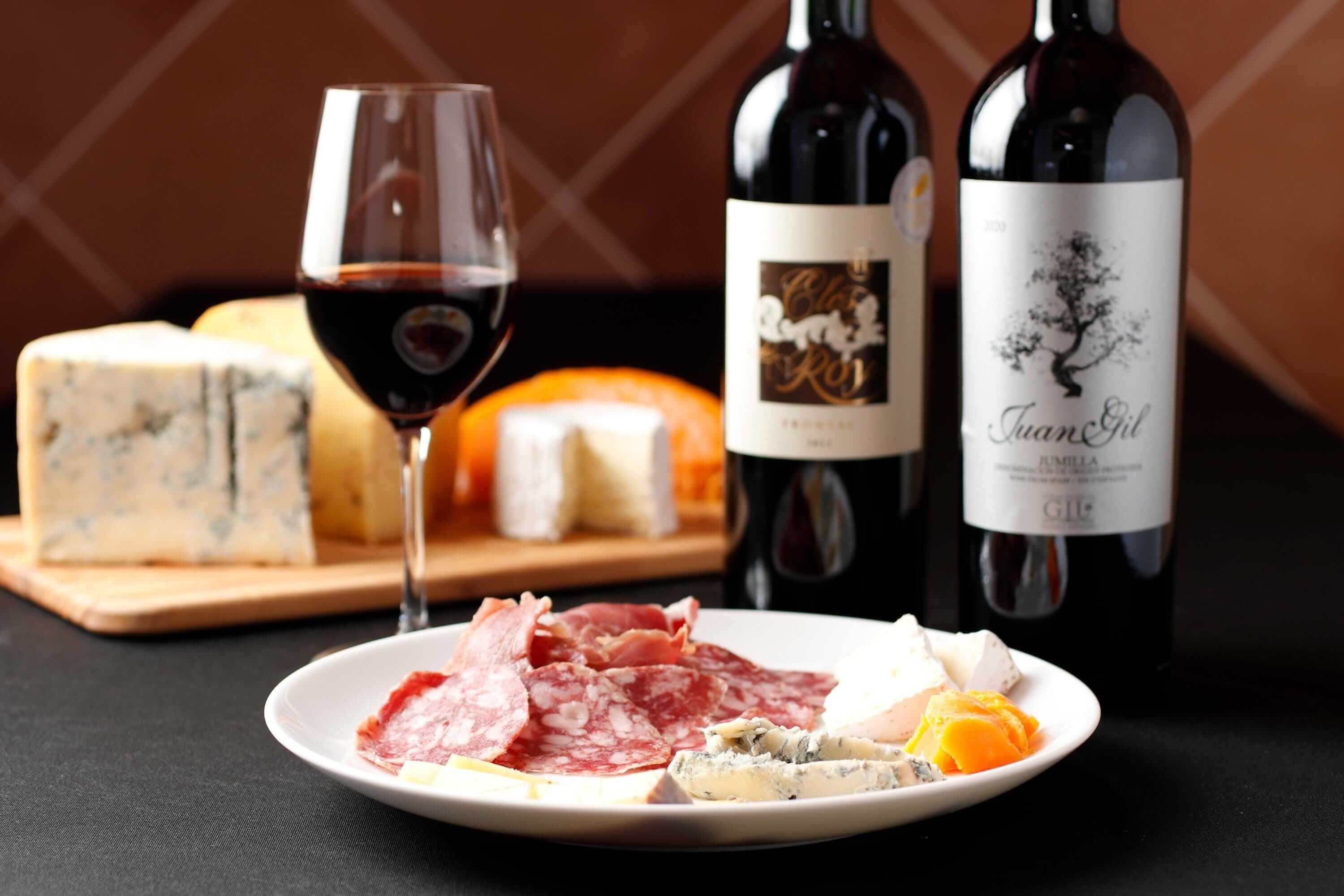 画像：お皿に乗ったチーズや生ハムと、ワイン